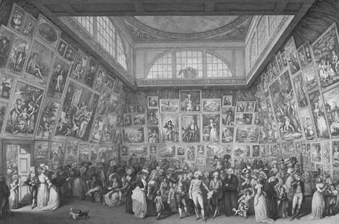 People examining paintings and miling about at an exhibition at the Royal Academy - Credit: The LIFE Picture Collection/Getty Images