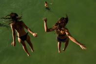 <p>Two women jump from a platform over the water at La Concha beach during a hot summer day in the basque city of San Sebastian, northern Spain, Friday, Aug. 3, 2018. (Photo: Alvaro Barrientos/AP) </p>