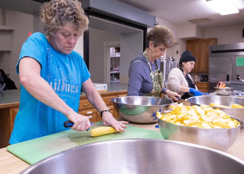 From left, volunteers Gayle Myers, Vera Teachout and Monica Bowe work to cut up vegetables for Compassion Delivered.