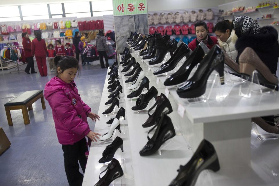 In this Thursday, Jan. 19, 2012 photo, a girl looks at shoes for women at the Kwangbok Area shopping center in Pyongyang, North Korea. A new culture of commerce is springing up, with China as its inspiration and source. The new consumerism is part of a campaign launched three years ago to build up the economy, and so the image of new leader Kim Jong Un. (AP Photo/David Guttenfelder)