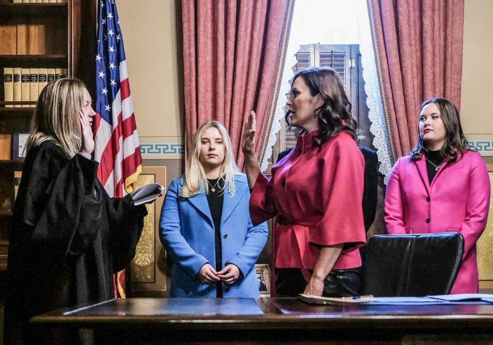 Gov. Gretchen Whitmer is sworn into office for a second term at her desk by Chief Justice Elizabeth Clement and is flanked by her daughters Sydney Whitmer, left, and Sherry Whitmer, Sunday, Jan. 1, 2023.