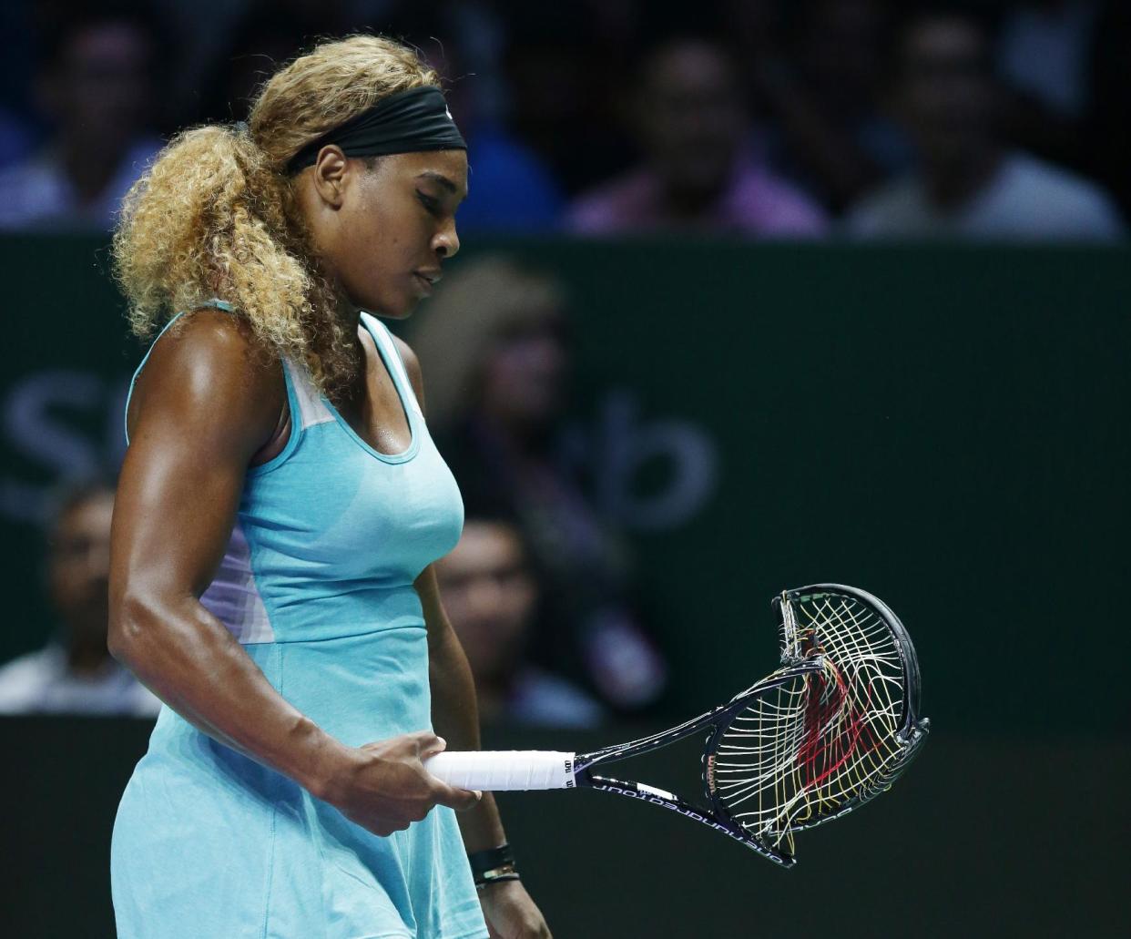 Serena Williams of the U.S. walks to her chair after smashing her racket in frustration during her semifinal match against Denmark&#39;s Caroline Wozniacki at the WTA tennis finals in Singapore, Saturday, Oct. 25, 2014. (AP Photo/Mark Baker)