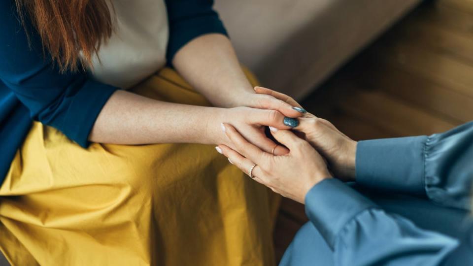 how to make friends: Two women sitting in armchairs and talking. Woman psychologist talking to patient woman. Coach giving hands to smiling woman. Therapist's gestures. Female talking in coworking office