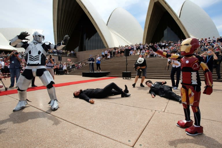 Nine-year-old Domenic Pace (R) acts out a scene as "Iron Boy" after police helped stage an elaborate event with the Make-A-Wish Foundation on the Sydney Opera House steps on February 11, 2016