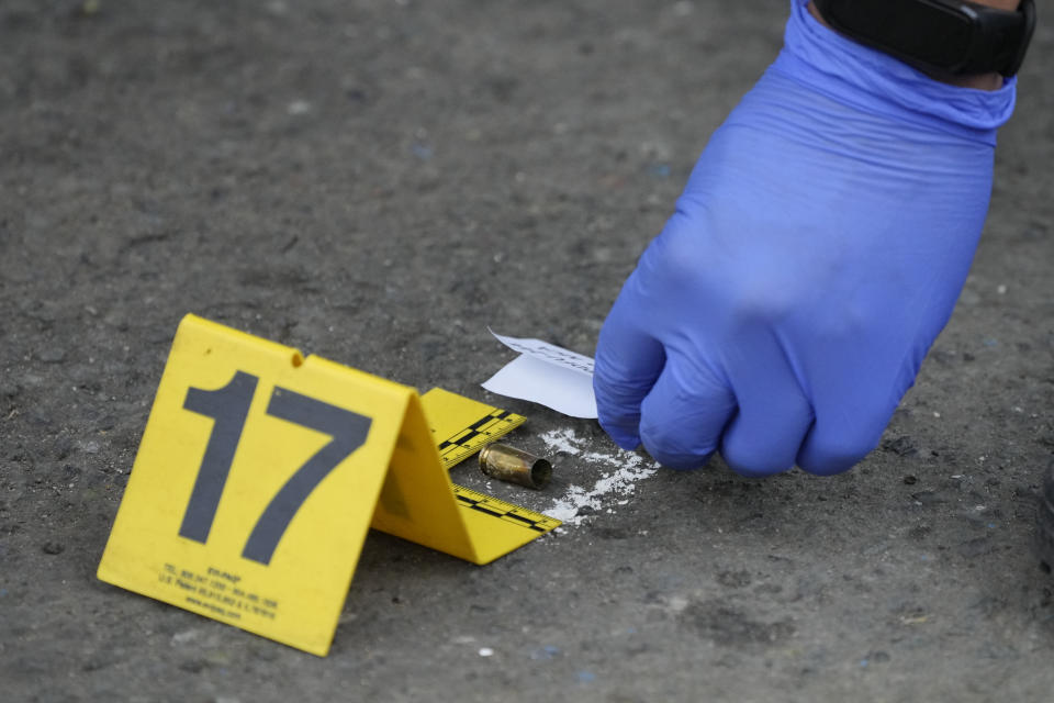 A bullet is marked by a police investigator at the scene, in front of the Ateneo de Manila University in Quezon city, Philippines, Sunday, July 24, 2022. At least three people, including a former Philippine town mayor, were killed and another was wounded in a brazen attack on Sunday by a gunman in a university campus in the capital region, officials said. (AP Photo/Aaron Favila)