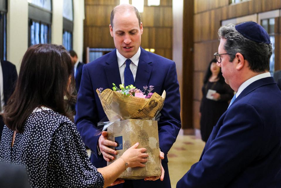 Britain's Prince William, Prince of Wales receives a bouquet of flowers for his wife Catherine, Princess of Wales during a visit to the Western Marble Arch Synagogue (POOL/AFP via Getty Images)