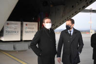 Slovak Prime Minister Igor Matovic, right, and Health Minister Marek Krajci at Kosice Airport, Slovakia, Monday March 1, 2021, as Russia's Sputnik V coronavirus vaccine arrives. Hard-hit Slovakia signed a deal to acquire 2 million dozes of Russia’s Sputnik V coronavirus vaccine. The country's prime minister says Slovakia will get one million shots in next two months while another million will arrive in May and June. (Frantisek Ivan/TASR via AP)