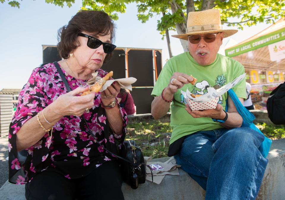 Pam and Cliff Lee of Stockton eat deep fried asparagus at the annual San Joaquin Asparagus Festival at the San Joaquin County Fairgrounds in Stockton on Friday, Apr. 14, 2023. Other delicacies to found at the festival included asparagus ice cream and asparagus on a stick. The 3-day event of all things asparagus concludes on Sunday.