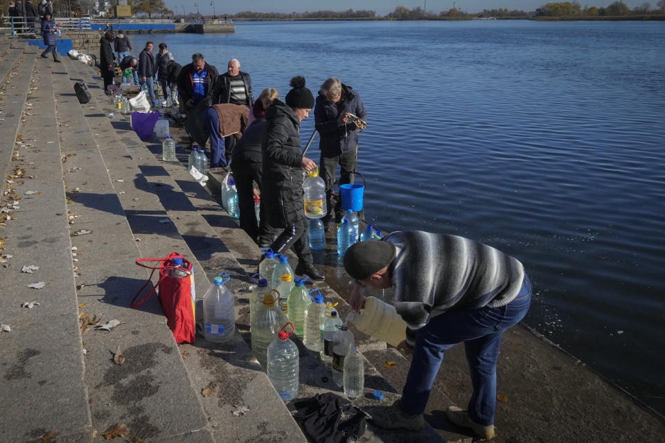 FILE - People collect water from a Dnipro river in Kherson, Ukraine, on Nov. 15, 2022. When Russian forces two months ago launched a military campaign against infrastructure in Ukraine, it opened an urgent second front far from the contact line: along power lines, water mains, and heating systems, and in places like homes, schools, offices and churches. (AP Photo/Efrem Lukatsky, File)