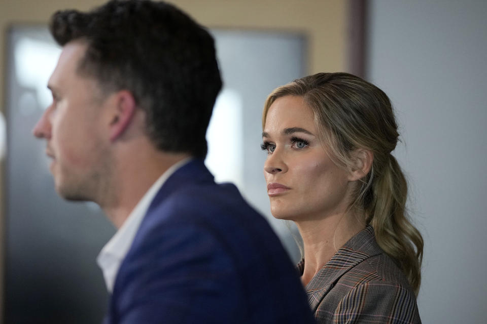 Kristen Posey, right, listens to her husband, San Francisco Giants catcher Buster Posey, talk during a news conference announcing his retirement from baseball, Thursday, Nov. 4, 2021, in San Francisco. (AP Photo/Tony Avelar)