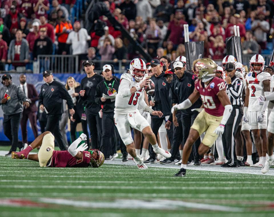 Louisville quarterback Jack Plummer (13) eluded the grasp of FSU's Patrick Payton (11) during first half action as the Louisville Cardinals faced off against the Florida State Seminoles in the 2023 ACC Championship game at Bank of America Field in Charlotte, NC, on Saturday, Dec. 2, 2023.