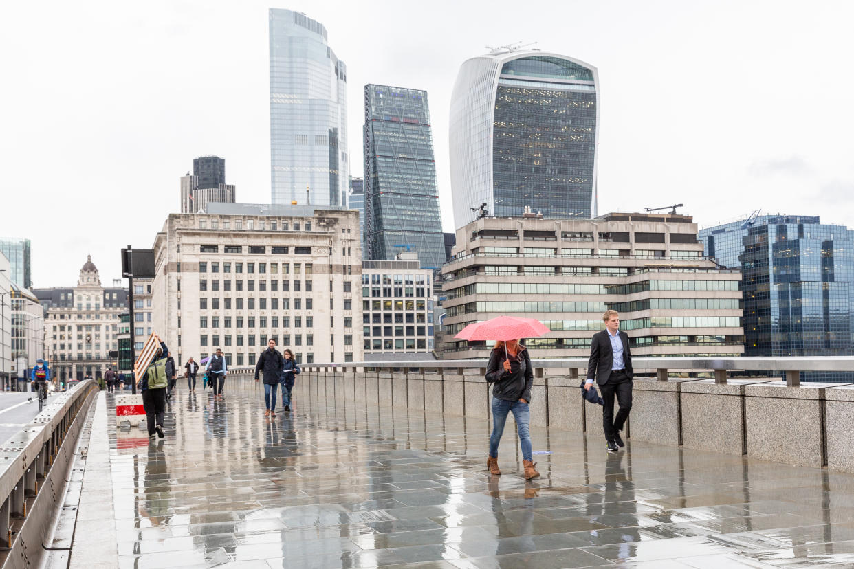 Pedestrians are seen on a rainy afternoon walking down London Bridge sideway by the City of London, largely abandoned as the second wave of Coronavirus hits London on September 30, 2020, London, England. World's financial hub is usually filled with white collar businessmen, today it stays largely empty as PM Boris Johnson advises people to work from home when possible. (Photo by Dominika Zarzycka/NurPhoto via Getty Images)