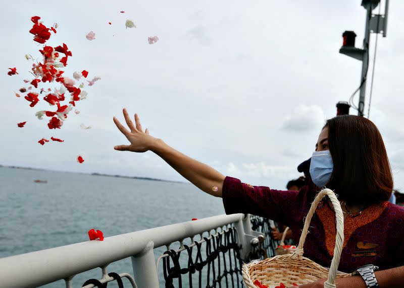 FILE PHOTO: A colleague of the crew of Sriwijaya Air flight SJ 182, which crashed into the sea, throws flowers and petals from the deck of Indonesia's Naval ship KRI Semarang as they visit the site of the crash to pay their tribute, at the sea off the Jaka
