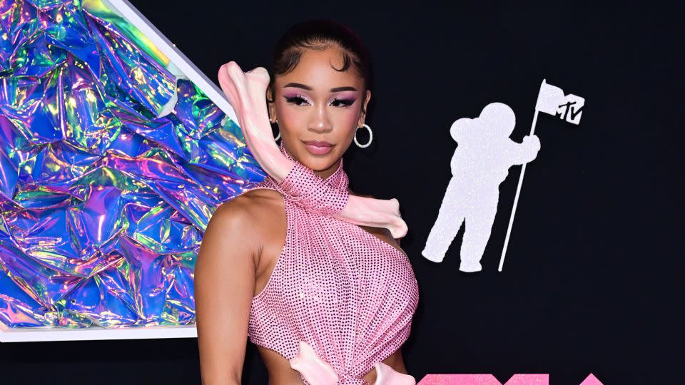 Saweetie, host of the awards' preshow, arrived early in a look straight from New York label Area's Fall/Winter 2023 couture runway. The rapper and singer said the pink dress, with its bone-shaped neck and waistline fastenings, was a "caveman" look that nods to "fashion when it first started."  - Anthony Harvey/Shutterstock