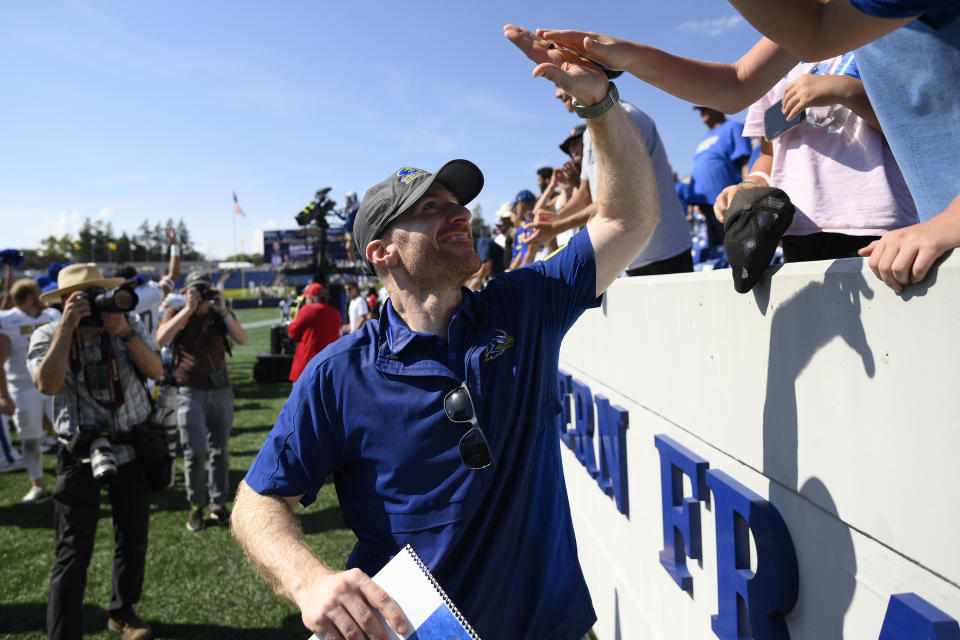 Delaware head coach Ryan Carty high fives fans after an NCAA college football game against Navy, Saturday, Sept. 3, 2022, in Annapolis, Md. Delaware won 14-7. (AP Photo/Nick Wass)