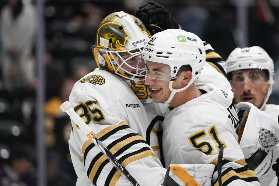 Boston Bruins center Matthew Poitras, right, celebrates with goaltender Linus Ullmark after the team's win against the Anaheim Ducks in an NHL hockey game Sunday, Oct. 22, 2023, in Anaheim, Calif. (AP Photo/Ryan Sun)