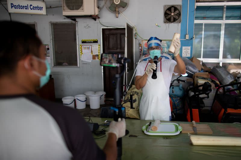 The Wider Image: Hazmat suits and holy water: two priests bring faith to Philippines lockdown