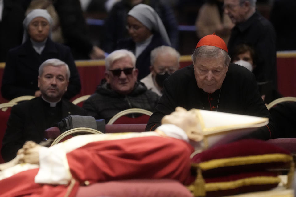 FILE - Australian Cardinal George Pell stands next to the body of late Pope Benedict XVI lying in state inside St. Peter's Basilica at The Vatican, Tuesday, Jan. 3, 2023. Pell, who was the most senior Catholic cleric to be convicted of child sex abuse before his convictions were later overturned, has died Tuesday, Jan. 10, 2023, in Rome at age 81. (AP Photo/Gregorio Borgia)