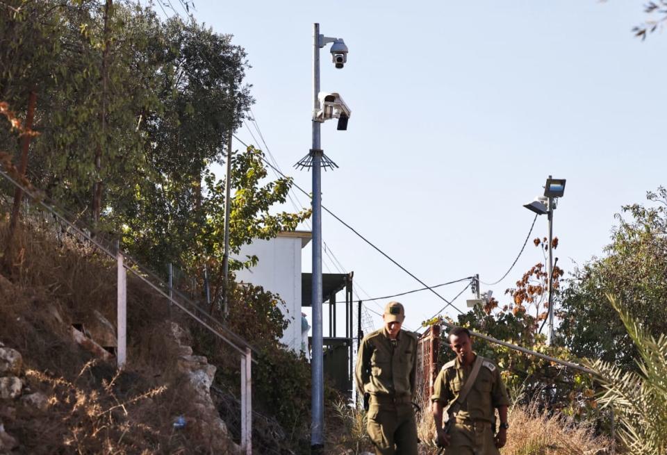 <div class="inline-image__caption"><p>Israeli soldiers walk past surveillance cameras in the flashpoint Palestinian city of Hebron on November 9, 2021. </p></div> <div class="inline-image__credit"> HAZEM BADER/AFP via Getty Images</div>