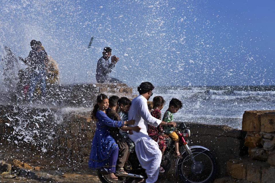 People enjoy high tide waves on the Arabian Sea in Karachi, Pakistan, Sunday, June 11, 2023. Pakistani Prime Minister Shehbaz Sharif ordered officials to put in place emergency measures in advance of the approaching Cyclone Biparjoy in the Arabian Sea. The "severe and intense" cyclone with wind speeds of 150 kilometers per hour (93 miles per hour) was on a course toward the country's south, Pakistan's disaster management agency said. (AP Photo/Fareed Khan)
