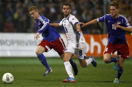 Bosnia's Miralem Pjanic (C) fights for the ball against Liechtenstein's Yves Oehri (L) and Nicolas Hasler (R) during their 2014 World Cup qualifying soccer match in Zenica, October 11, 2013. REUTERS/Dado Ruvic