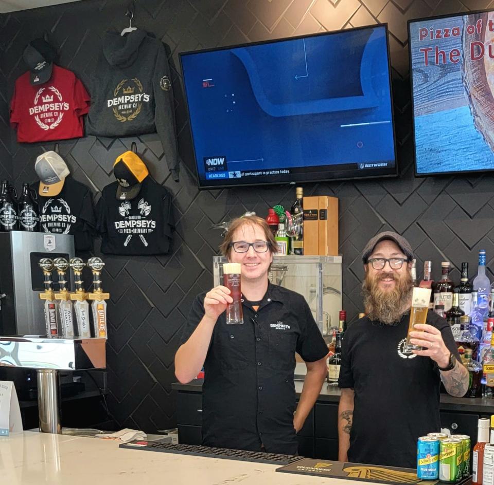 Sean Dempsey, left, and David Solum toast their house brews for the opening of Dempsey's third location at the Watertown Regional Airport.