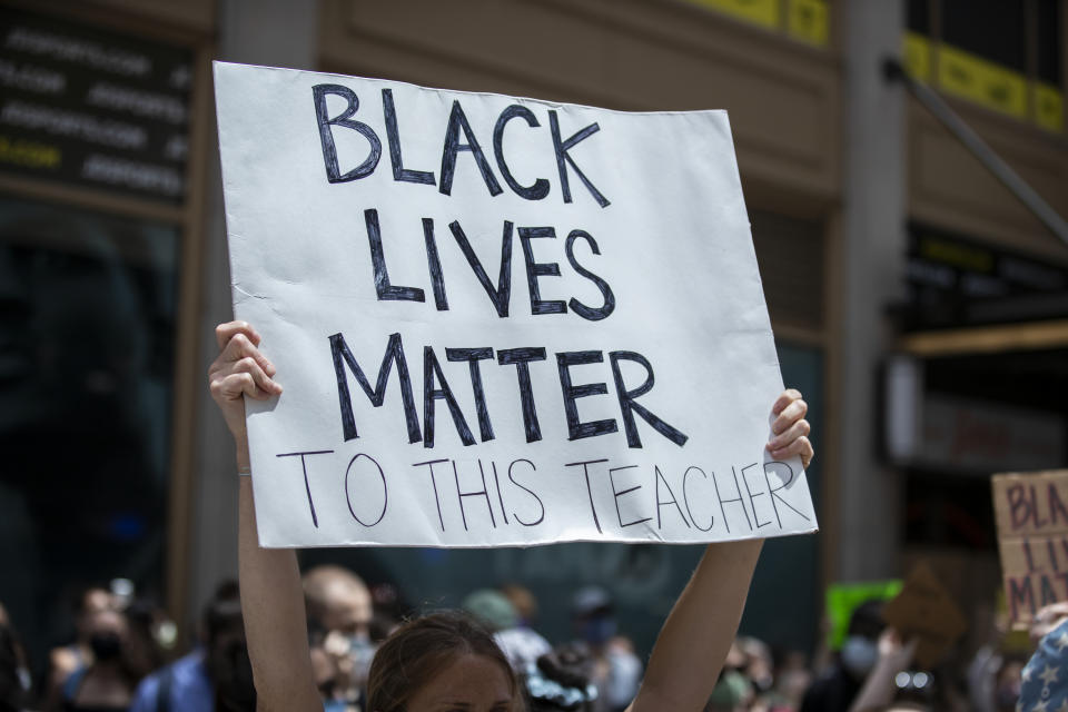 A white protester in Times Square holds a handmade sign that reads, "Black Lives Matter To This Teacher".  (Photo by Ira L. Black/Corbis via Getty Images)