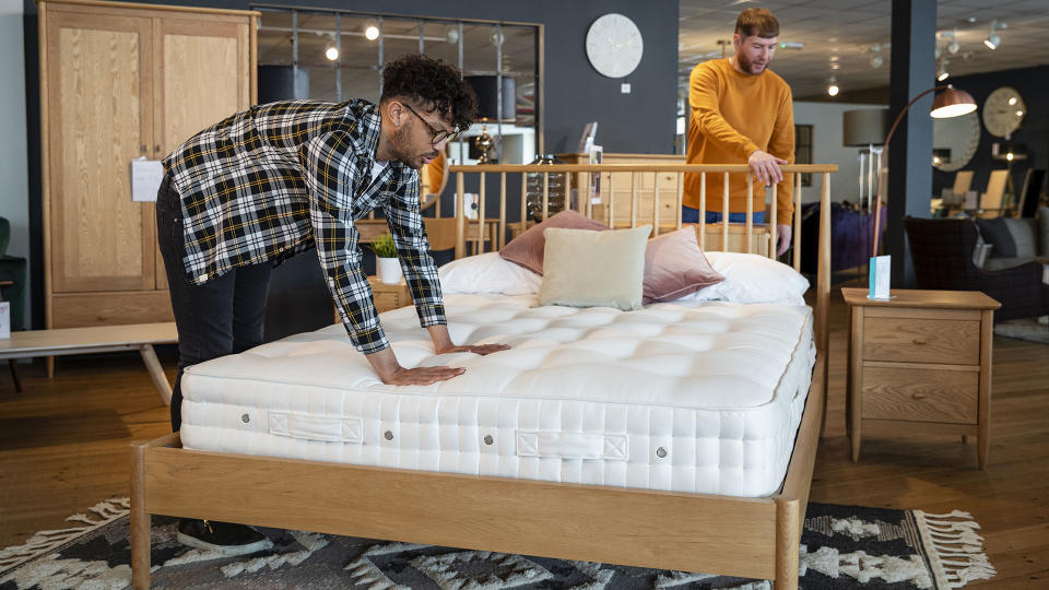 Couple testing out mattresses in a showroom