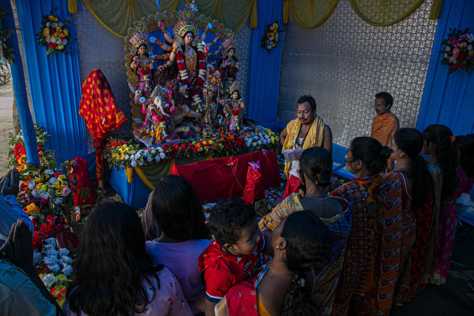 Devotees offer prayers during Durga Puja festival in Gauhati, India, Saturday, Oct. 24, 2020. Weeks after India fully opened up from a harsh lockdown and began to modestly turn a corner by cutting new infections by near half, a Hindu festival season is raising fears that the disease could spoil the hard-won gains. Health experts worry the festivals can set off a whole new cascade of infections, further testing and straining India’s battered health care system. (AP Photo/Anupam Nath)