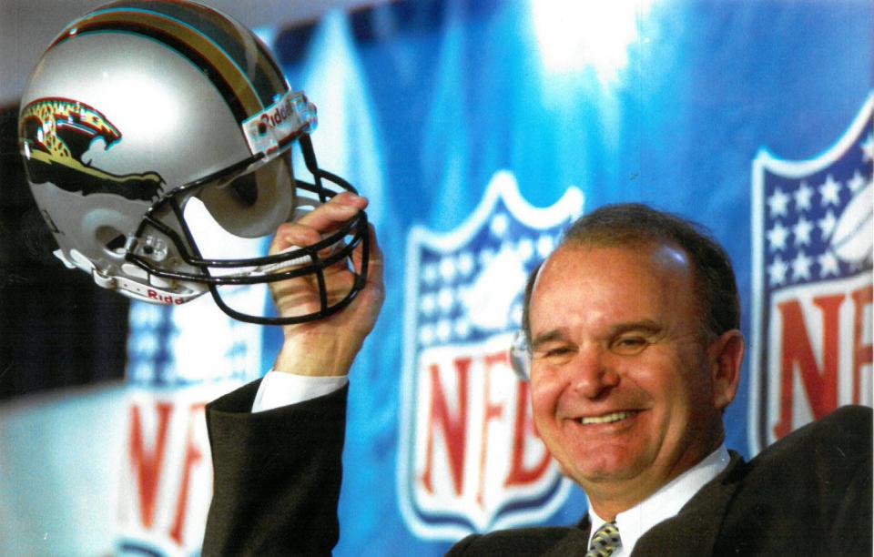 Wayne Weaver holds up a Jaguars helmet while celebrating NFL owners' 1993 decision to award a team franchise to Jacksonville. (Gary T. Clark/Florida Times-Union)