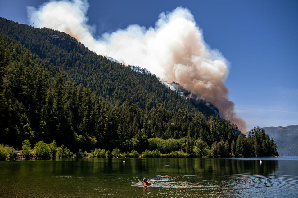 A swimmer in Cameron Lake in front of the Cameron Bluffs wildfire near Port Alberni, British Columbia, Canada, on Tuesday, June 6, 2023. Canada is on track to see its worst-ever wildfire season in recorded history if the rate of land burned continues at the same pace. Photographer: James MacDonald/Bloomberg