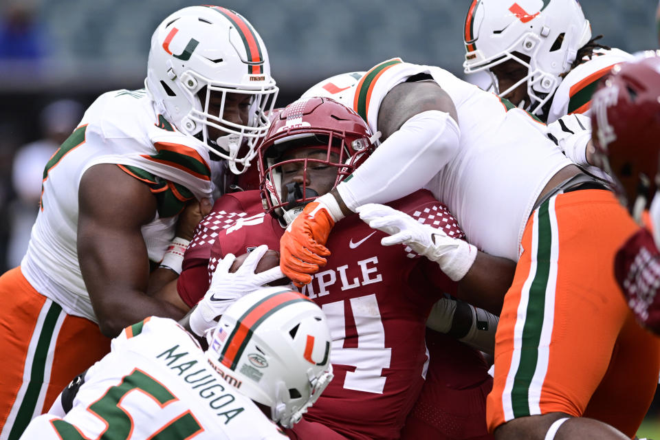 Temple running back Joquez Smith, center, is tackled by the Miami defense during the first half of an NCAA college football game, Saturday, Sept. 23, 2023, in Philadelphia. (AP Photo/Derik Hamilton)