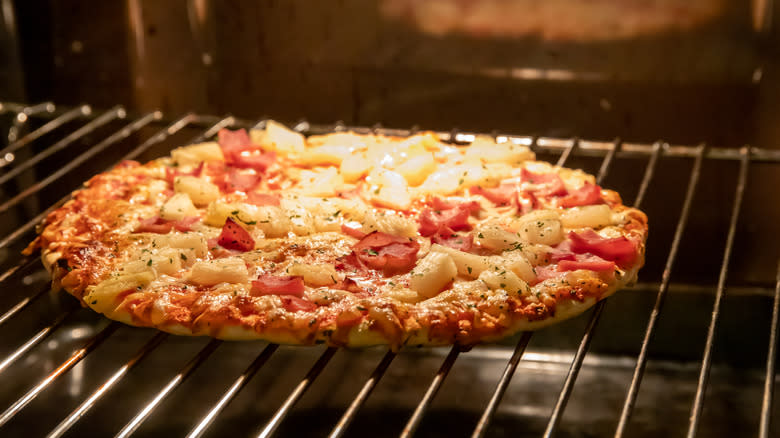 Frozen pizza cooking in oven