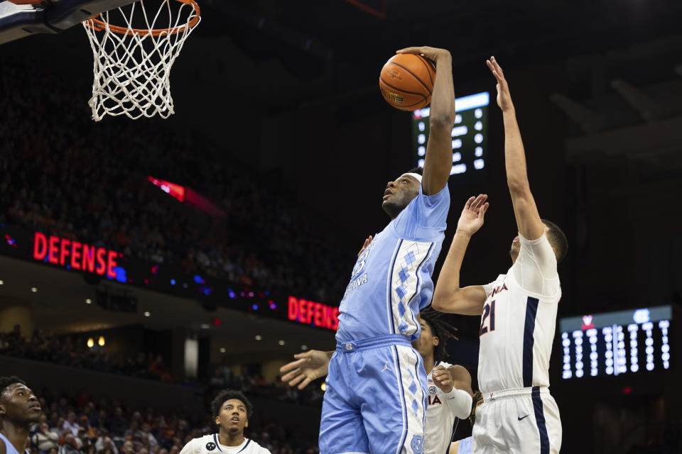 North Carolina's Jalen Washington, center, tries to shoot the ball against Virginia during the first half of an NCAA college basketball game in Charlottesville, Va., Tuesday, Jan. 10, 2023. (AP Photo/Mike Kropf)