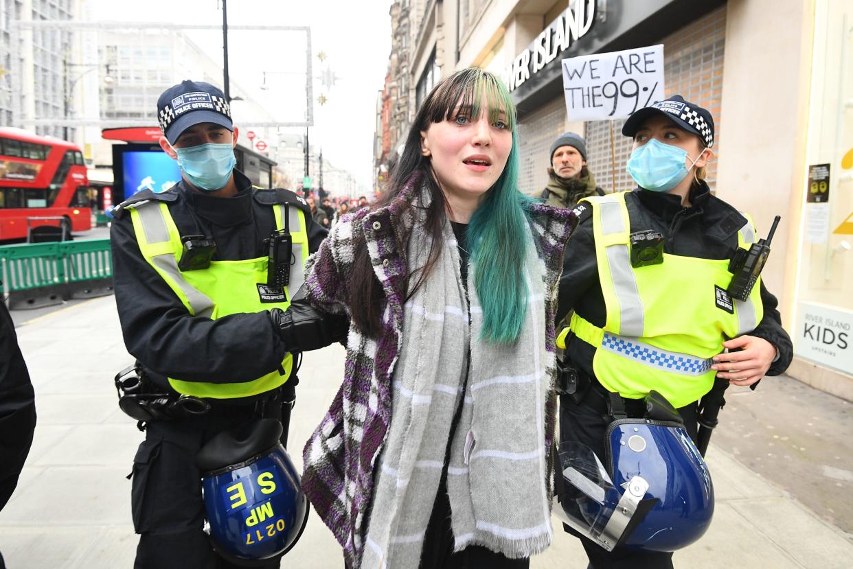 <p>One protesters is led away by police outside King’s Cross station</p> (PA)