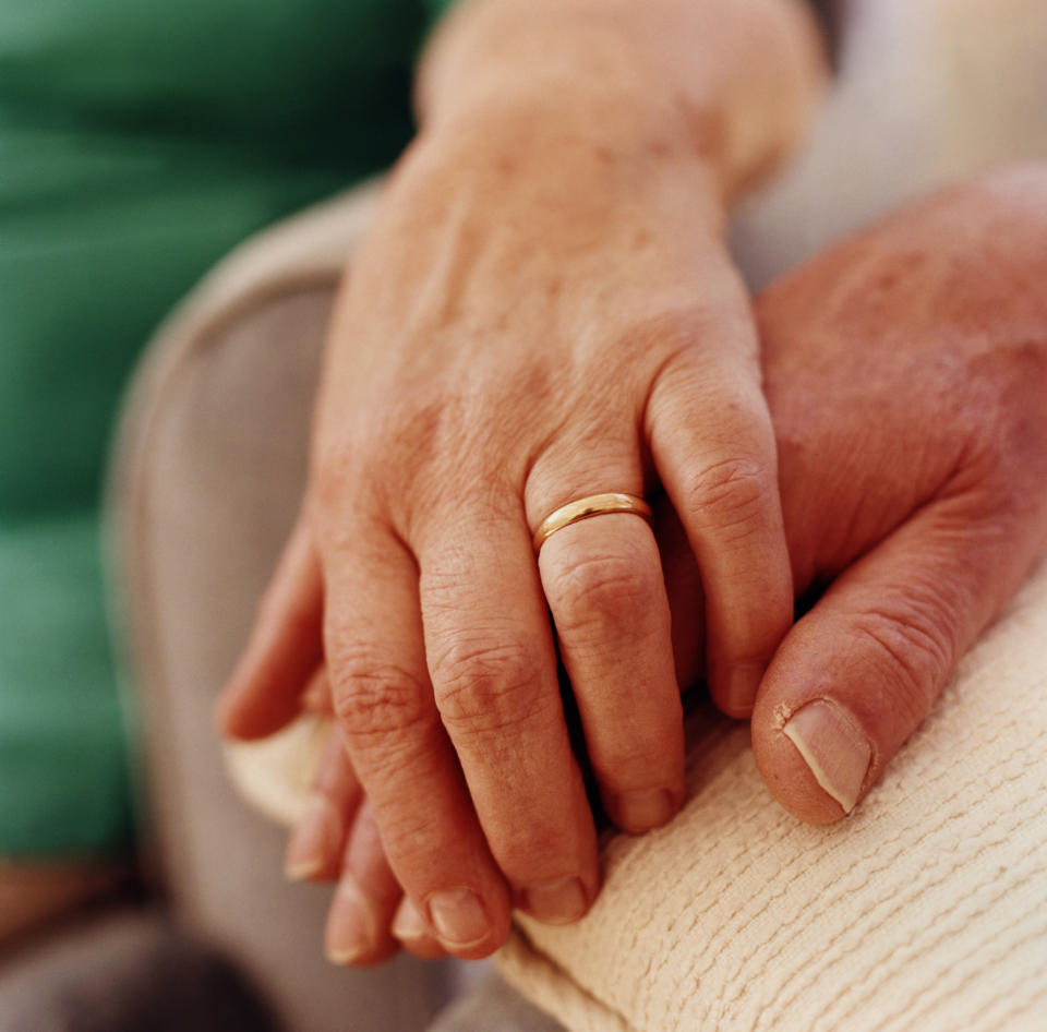 A person with their hand over their partner's hand