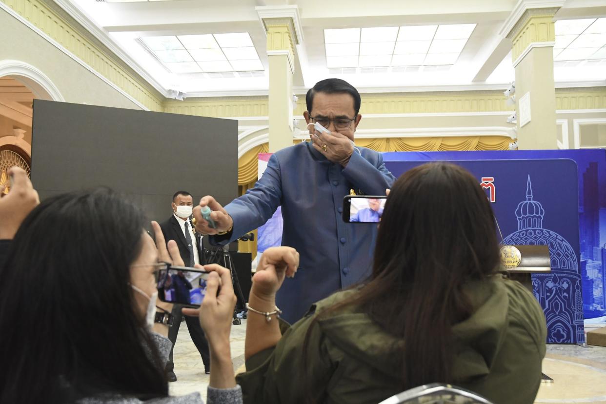 Thailand's Prime Minister Prayuth Chan-ocha sprays alcohol mist on a front row of reporters sitting inside the press conference room at Government house in Bangkok, Thailand, Tuesday, March 9 , 2021. Riled by a final question about a possible Cabinet reshuffle, the prime minister told reporters to mind their own business, then grabbed a container of alcohol mist and doused the front row before sauntering off. 