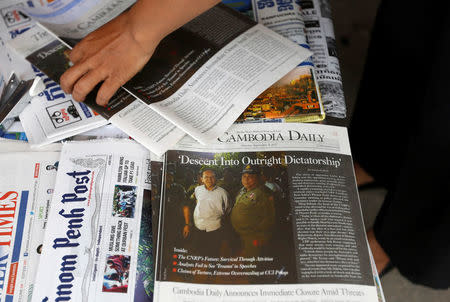 A vendor prepares a stack of the final issue of The Cambodia Daily newspaper at her store for sale along a street in Phnom Penh, Cambodia, September 4, 2017. REUTERS/Samrang Pring