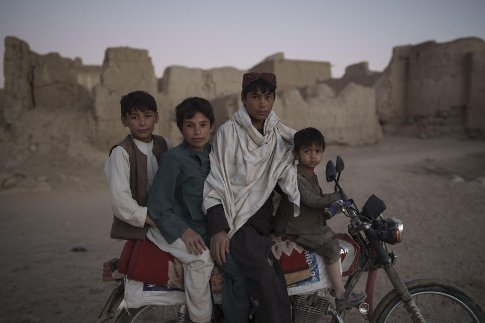 Afghan boys pose for a photo while riding a motorcycle in Salar village, Wardak province, Afghanistan, Tuesday, Oct. 12, 2021. In urban centers, public discontent toward the Taliban is focused on threats to personal freedoms, including the rights of women. In Salar, these barely resonate. The ideological gap between the Taliban leadership and the rural conservative community is not wide. Many villagers supported the insurgency and celebrated the Aug. 15 fall of Kabul which consolidated Taliban control across the country. (AP Photo/Felipe Dana)