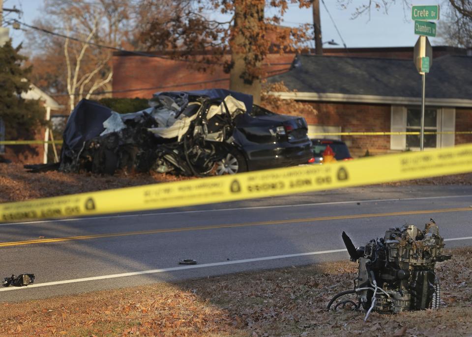 An engine lays on the side of the road near one of the vehicles involved in a crash on Chambers Road in Bellefontaine, Mo. Detective Antonio Valentine died in the line of duty and a suspect he was trying to stop also died in a head-on collision of their vehicles. The crash happened Wednesday, Dec. 1, 2021, in north St. Louis County after officers with the department’s drug unit tried to stop a car that had been reported stolen, police said. (David Carson/St. Louis Post-Dispatch via AP)