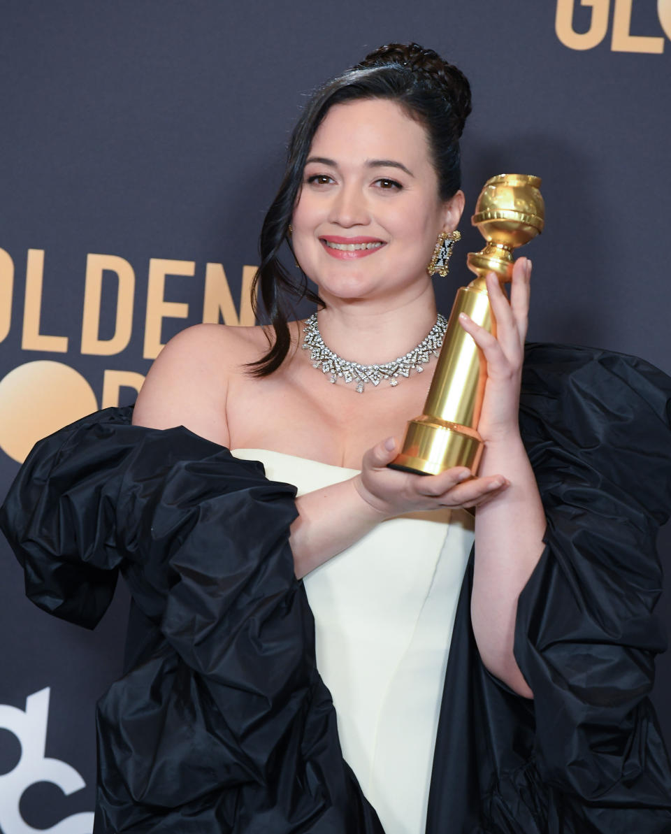 Lily Gladstone holding her Golden Globe