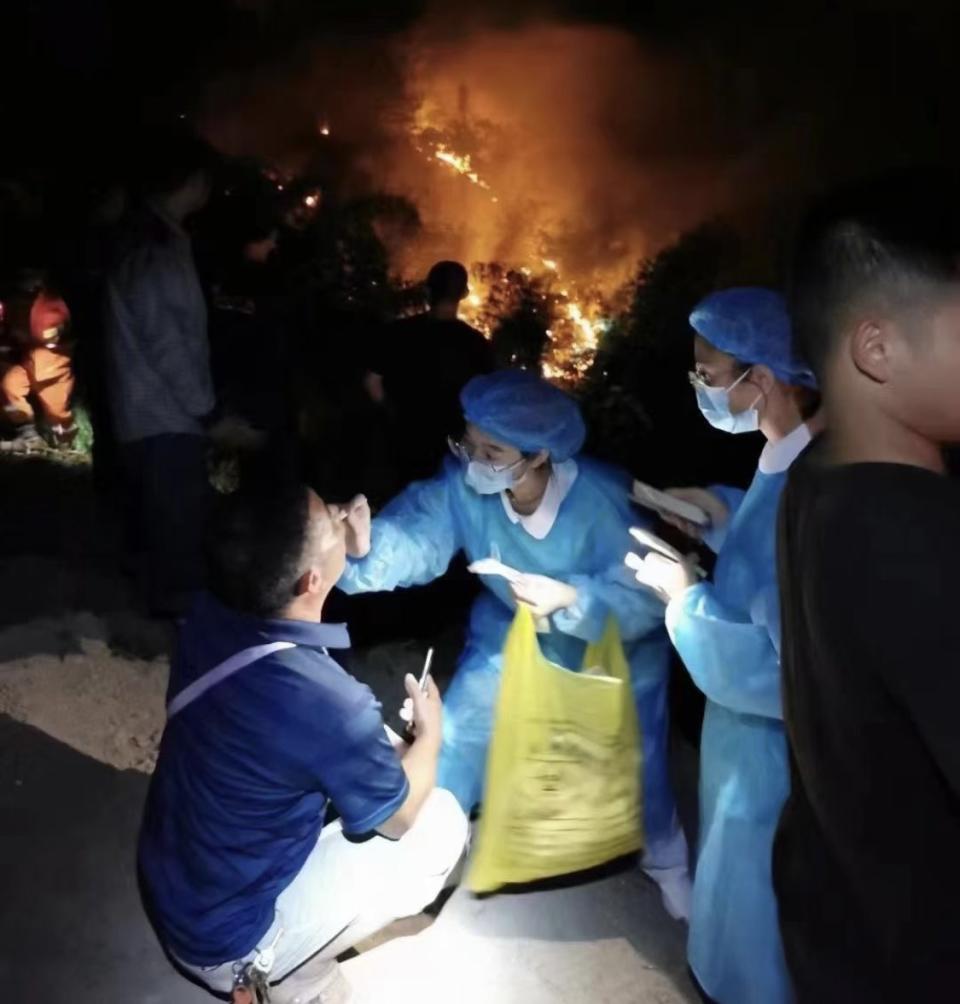 Chinese workers carry out Covid testing as wildfires rage nearby.