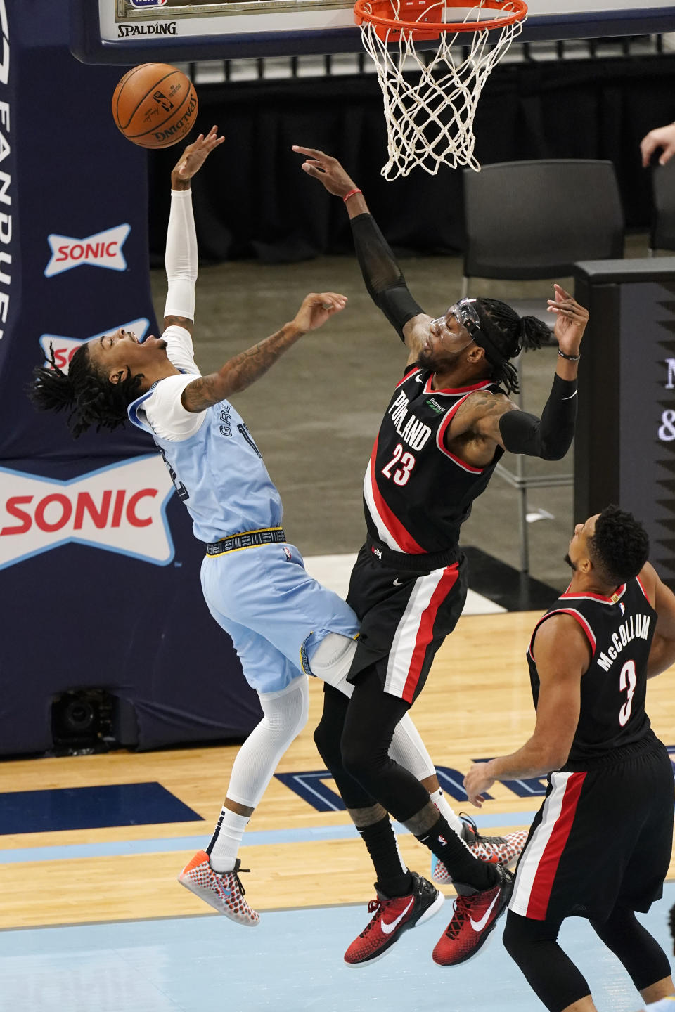 Memphis Grizzlies' Ja Morant, left, drives against Portland Trail Blazers' Robert Covington (23) in the second half of an NBA basketball game Wednesday, April 28, 2021, in Memphis, Tenn. (AP Photo/Mark Humphrey)