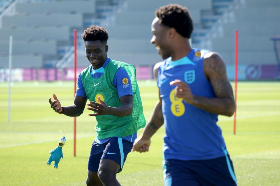 England’s Bukayo Saka and Raheem Sterling throw a rubber toy during a training session at Al Wakrah Stadium (The FA via Getty Images)