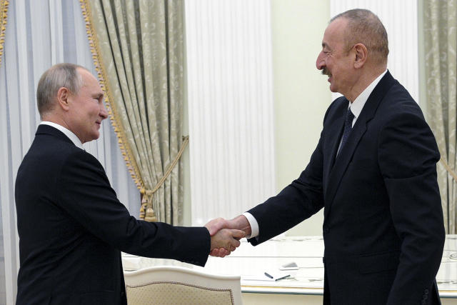 Russian President Vladimir Putin, left, greets Azerbaijan's President Ilham Aliyev prior to their talks in the Kremlin in Moscow, Russia, Monday, Jan. 11, 2021. Putin hosted the leaders of Armenia and Azerbaijan for talks after six weeks of fierce fighting over Nagorno-Karabakh that ended with a Russia-brokered peace deal in November. (Mikhail Klimentyev, Sputnik, Kremlin Pool Photo via AP)