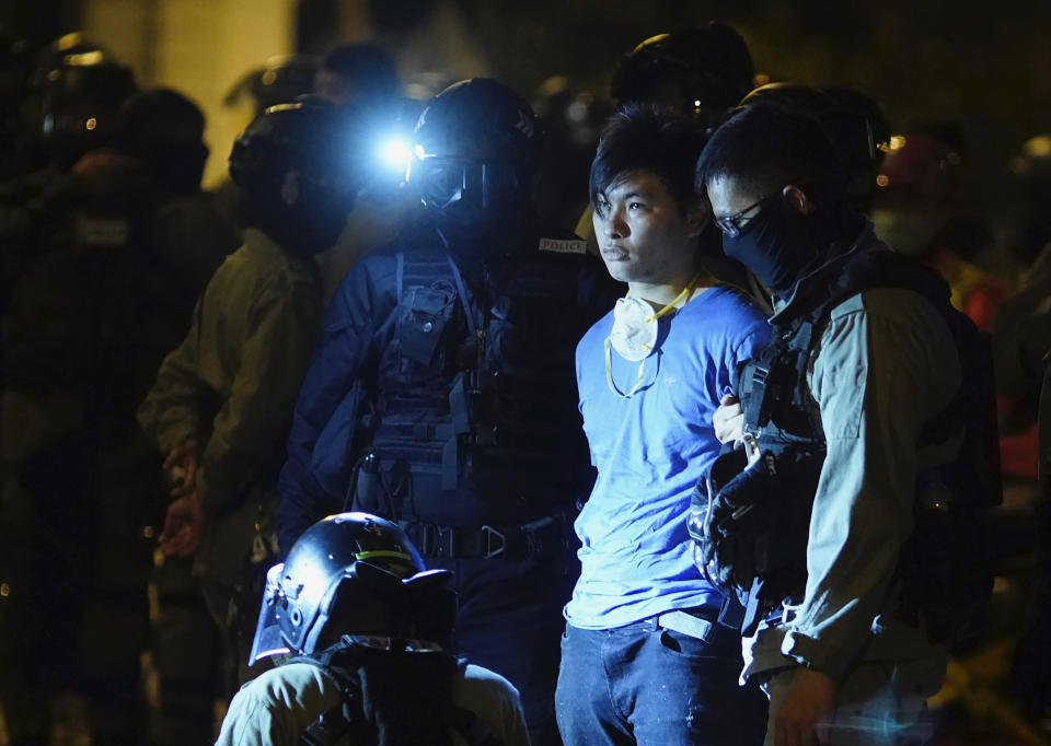 Riot police detain a protestor after he tried to escape from Hong Kong Polytechnic University in Hong Kong, Tuesday, Nov. 19, 2019. About 100 anti-government protesters remained holed up at a Hong Kong university Tuesday, their choices dwindling along with their food supplies as they braced for the endgame in a police siege of the campus that entered its third day. (AP Photo/Vincent Yu)