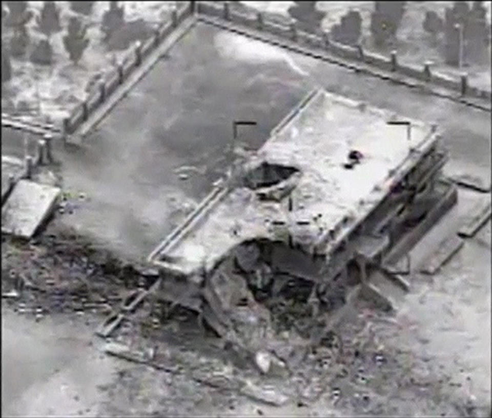 A still image taken from video provided by the U.S. Central Command shows a damaged building at an Islamic State (IS) compound near the northern Syrian town of Ar Raqqah, following an air strike against IS targets September 23, 2014. The United States and its Arab allies bombed militant groups in Syria for the first time on Tuesday, killing scores of Islamic State fighters, members of a separate al Qaeda-linked group and opening a new front amid shifting Middle East alliances. REUTERS/U.S. Central Command/Handout via Reuters TV (SYRIA - Tags: MILITARY POLITICS CONFLICT TPX IMAGES OF THE DAY) ATTENTION EDITORS - THIS PICTURE WAS PROVIDED BY A THIRD PARTY. REUTERS IS UNABLE TO INDEPENDENTLY VERIFY THE AUTHENTICITY, CONTENT, LOCATION OR DATE OF THIS IMAGE. FOR EDITORIAL USE ONLY. NOT FOR SALE FOR MARKETING OR ADVERTISING CAMPAIGNS. THIS PICTURE IS DISTRIBUTED EXACTLY AS RECEIVED BY REUTERS, AS A SERVICE TO CLIENTS