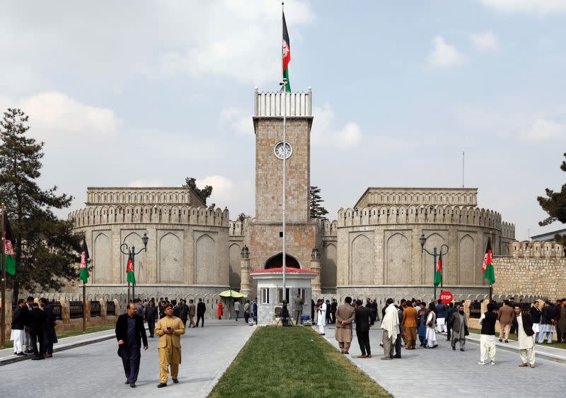 Men walk outside presidential palace before President Ghani's oath during his inauguration as president in Kabul