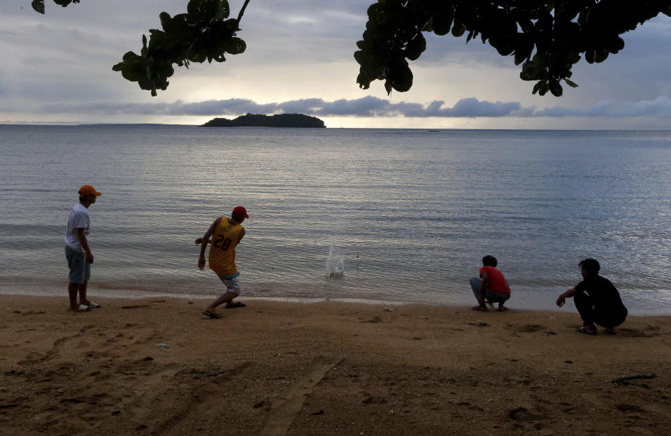 In this Jan. 27, 2019 photo, four boys play by the shore at a beach resort in Talustusan on Biliran Island in the central Philippines. Since December 2018, the small village has been rocked by controversy after about 20 boys and men, including these four, accused their Catholic parish priest Father Pius Hendricks of years of alleged sexual abuse. (AP Photo/Bullit Marquez)