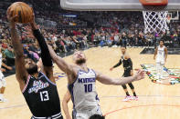 Los Angeles Clippers forward Paul George, left, grabs a rebound away from Sacramento Kings forward Domantas Sabonis during the first half of an NBA basketball game Friday, Feb. 24, 2023, in Los Angeles. (AP Photo/Mark J. Terrill)